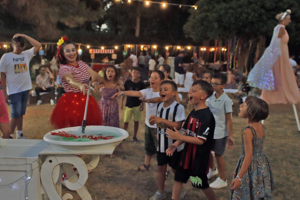 Estate a Baia di Gallipoli: la festa del villaggio tra musica, danza e tradizione

L’estate a Baia di Gallipoli è un'esperienza unica, che abbraccia la cultura e la magia della Puglia. Da maggio a ottobre, la Piazza Centrale ospita la Festa del Villaggio, l'evento più amato e atteso, che celebra la tradizione con musica, balli e spettacoli. La pizzica di Stella Grande, i circensi e i mangiafuoco creano un’atmosfera di pura magia, dove ogni nota e ogni danza raccontano storie senza tempo.

Un rito collettivo che unisce grandi e bambini, che invita a ballare senza freni e a godersi il piacere di stare insieme. In Puglia, la festa è molto più di un evento: è una prova che la felicità, quando condivisa, vale di più. Baia di Gallipoli è il cuore pulsante di un’estate che non finisce mai, un tempo sospeso dove ogni momento diventa un ricordo da vivere.
